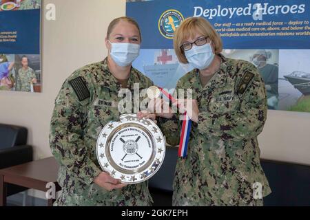 210825-N-KK394-1020 STAZIONE NAVALE MAYPORT, Fl. (agosto 25, 2021) Hospitalman Patsy Erwin pone per una foto con il capitano Teresa Allen, comandante, ospedale navale di Jacksonville, in riconoscimento del suo contributo alla squadra di softball della Marina per il campionato di softball femminile delle forze armate 2021. Il team Navy ha vinto il titolo di campionato per la prima volta in 35 anni. Foto Stock