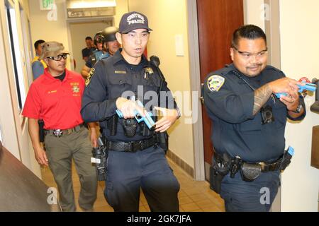 Da sinistra a destra, come Sgt. Edward durante, procuratore di esercizi presso l’ufficio dello sceriffo della contea di Santa Clara, cammina accanto al funzionario della pubblica sicurezza S. Kotani, al Dipartimento della pubblica sicurezza di Sunnyvale (legge), e al funzionario della polizia Alan Corpuz del Dipartimento della polizia di Mountain View, mentre co-guidano una Task Force di soccorso durante la formazione di risposta allo sparatutto attivo, presso lo Sgt. James Witowski Armed Forces Reserve Center, a Mountain View, California, 26 agosto 2021. Foto Stock