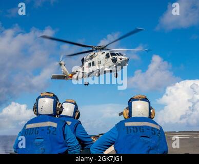 MAR DELLE FILIPPINE (ago. 26, 2021) Un Superhawk della forza di autodifesa marittima del Giappone atterra sul ponte di volo del cacciatorpediniere missilistico guidato di classe Arleigh Burke USS Barry (DDG 52) durante MALABAR 2021. Barry è attualmente in dispiegamento a supporto del Commander, Task Force 71 (CTF 71)/Destroyer Squadron 15 (DESRON 15), il più grande DESRON schierato in avanti della Marina e della principale forza di superficie della 7a flotta statunitense. Foto Stock