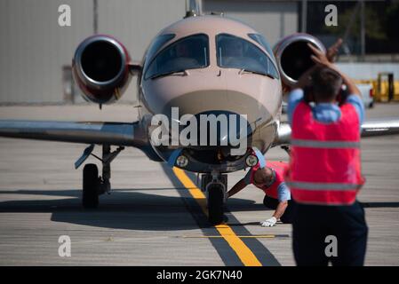 Gli appaltatori con l'ottantesimo ufficio di allerta transitoria della logistica di Squadron marshallano un aereo dell'aeronautica T-1 Jayhawk assegnato al 48esimo Squadron di addestramento di volo, base dell'aeronautica di Columbus, Mississippi, nel relativo punto di parcheggio a Wright-Patterson AFB, Ohio, 27 agosto 2021. Sette aerei con 48 FTS, su un volo di allenamento per il Michigan, si fermavano a Wright-Patt per il carburante. Foto Stock