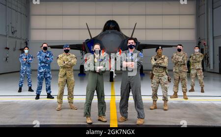 Piloti, forze di sicurezza, manutentori di aeromobili e personale logistico della Royal Australian Air Force (a sinistra) e della U.S. Air Force (a destra) posano di fronte a una F-35A Lightning II assegnata al 355th Fighter Squadron durante LA BANDIERA ROSSA-Alaska 21-3 sulla base dell'aeronautica Eielson, Alaska, 27 agosto 2021. Questa iterazione dell'esercizio si è concentrata sull'interoperabilità di risorse alleate di quinta generazione, come il F-35A Lightning II, nonché sulle capacità di guerra informatica e di intelligence. Foto Stock