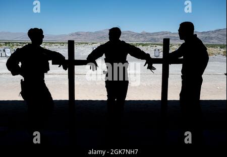 Tre Airmen assegnati al 99th Tactical Response Team riposano dopo un'esercitazione avanzata di combattimento a Nellis Air Force base, Nevada, 28 agosto 2021. Il percorso avanzato di combattimento aumenta la velocità e la precisione dello sparatutto, utilizzando una serie di diversi bersagli in carta e acciaio, in cui eseguono esercitazioni che sfidano sia gli aspetti fisici che mentali di possibili impegni in un ambiente stressante a distanze variabili. Foto Stock