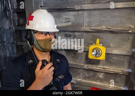 MAR DELLE FILIPPINE (ago. 30, 2021) Hospital Corpsman 1st Class Douganta Yang, di Chico, California, parla in un telefono a potenza sonora durante un test di caduta ancora nel ventlass ancora a bordo della nave da combattimento litoranea variante Independence USS Jackson (LCS 6). Jackson, parte di Destroyer Squadron Seven, è in fase di implementazione rotazionale, operando nella settima area operativa della flotta per migliorare l'interoperabilità con i partner e fungere da forza di risposta pronta a sostegno di una regione indopacifica libera e aperta. Foto Stock