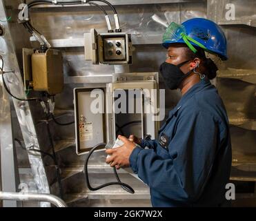 MAR DELLE FILIPPINE (ago. 30, 2021) Boatswain’s Mate 1st Jamila Smith, di Brooklyn, N.Y.., opera l'attrezzatura di ancoraggio durante un test di caduta dell'ancora nel windlass dell'ancora a bordo della nave da combattimento litoranea variante di Independence USS Jackson (LCS 6). Jackson, parte di Destroyer Squadron Seven, è in fase di implementazione rotazionale, operando nella settima area operativa della flotta per migliorare l'interoperabilità con i partner e fungere da forza di risposta pronta a sostegno di una regione indopacifica libera e aperta. Foto Stock