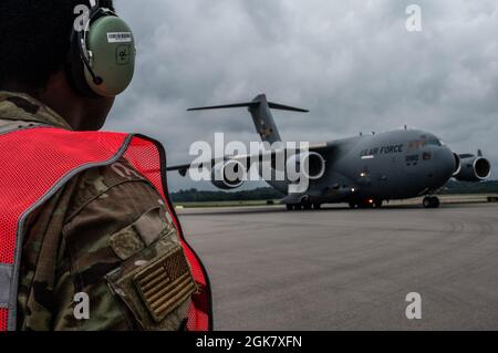 Senior Airman Elijah Turner, 911th Aircraft Maintenance Squadron Crew Chief, guarda come un C-17 Globemaster III taxi sulla linea di volo alla stazione della riserva aerea dell'aeroporto internazionale di Pittsburgh, Pennsylvania, 31 agosto 2021. Il velivolo e l'equipaggio sono tornati a Pittsburgh dopo aver partecipato agli sforzi di evacuazione in Afghanistan. Foto Stock