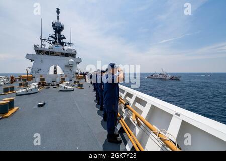 I membri della Guardia Costiera degli Stati Uniti Cutter Munro salutano una nave della Guardia Costiera delle Filippine che transita lungo il Munro nel Mare delle Filippine Occidentali, 31 agosto 2021. I membri della Guardia Costiera a bordo del Munro e della Guardia Costiera filippina hanno partecipato a operazioni ed esercizi bilaterali che includevano operazioni di piccole imbarcazioni e manovre multivascello. Foto Stock