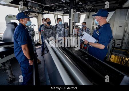 I membri del Crewmembers della guardia costiera degli Stati Uniti Cutter Munro e della guardia costiera filippina partecipano agli esercizi di addestramento bilaterale nel Mare delle Filippine Occidentali, 31 agosto 2021. Il Munro e il suo equipaggio sono attualmente dislocati nel Pacifico occidentale, con scambi professionali pianificati e lo sviluppo di capacità con le nazioni partner nella regione. Foto Stock