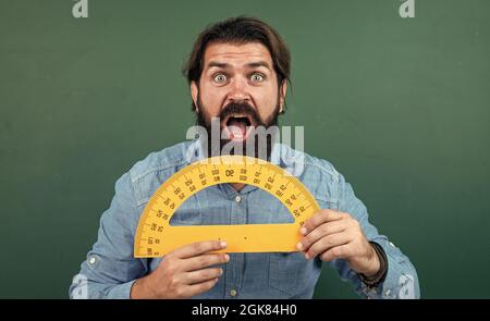 uomo sorpreso con le dimensioni misurate su strumento di matematica del righello del prostititore, istruzione scolastica Foto Stock