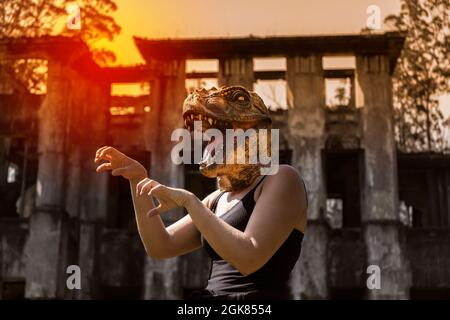 Donna in maschera di dinosauro gesturing con le mani terrore Halloween concetto Foto Stock