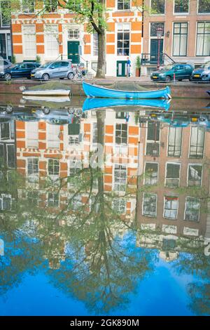 Amsterdam Olanda - Agosto 19 2017; le case dei canali e le barche si riflettono nella calma e pacifica composizione verticale delle acque dei canali. Foto Stock