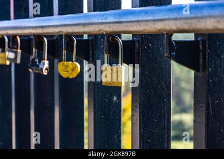 Primo piano Vista dei Padlock d'Amore che si aggrappano su una fence del Ponte Foto Stock