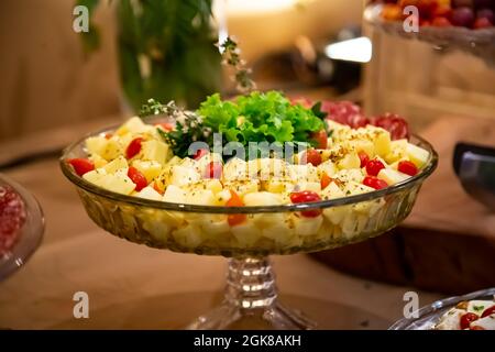 Salada com tomate, queijo e folhas de alface em uma tigela de vidro. Foto Stock