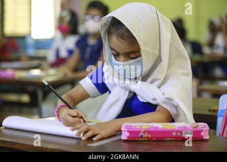 Dhaka, Bangladesh. 13 settembre 2021. Dopo la riapertura di tutti gli istituti di istruzione, gli studenti hanno frequentato le classi scolastiche in seguito alla facilità delle restrizioni COVID-19, a Dhaka, Bangladesh, il 13 settembre 2021. Le scuole di tutto il paese hanno riaperto la domenica dopo una lunga chiusura di un anno e mezzo. Oggi, lunedì, è il secondo giorno di scuola dalla riapertura. (Foto di Suvra Kanti Das/Sipa USA) Credit: Sipa USA/Alamy Live News Foto Stock