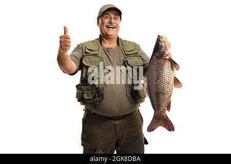 Felice pescatore tenendo un grande pesce carpa e gesturando un pollice su segno isolato su sfondo bianco Foto Stock