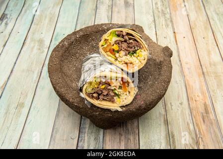 Arrosto di manzo messicano e burrito di menta piperita con un sacco di pepe rosso e lattuga arrotolata con tortilla di grano Foto Stock