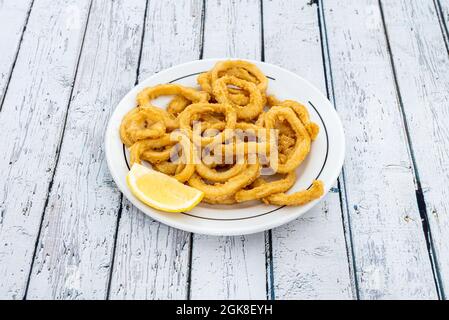 Porzione di calamari fritti a la romana su un piatto rotondo Foto Stock