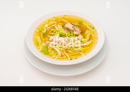 brodo di pollo caldo e delizioso con verdure all'interno di un recipiente bianco Foto Stock