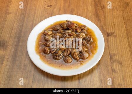 Tipica ricetta spagnola di lumache stufate in salsa presentata in un ristorante di tapas di Madrid Foto Stock