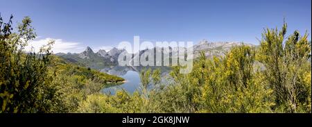 Pittoresco paesaggio panoramico di Riano Reservoir circondato da montagne rocciose e alberi verdi nella soleggiata giornata estiva con cielo blu a Leon in Spagna Foto Stock