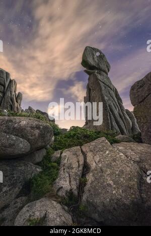 Pittoresco paesaggio di formazioni rocciose ruvide sulla cima della montagna sotto il cielo stellato in serata Foto Stock