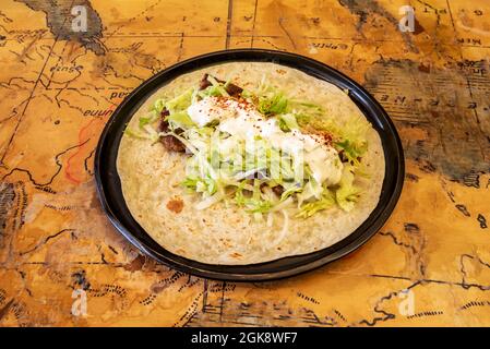 Durum kofte con insalata, yogurt e paprika su pane piatto non chiuso servito in un ristorante turco Foto Stock