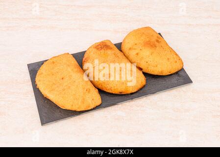 Ricetta per le empanadas cilene farcite di carne su un piatto di ardesia nera su un tavolo di marmo Foto Stock