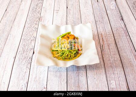 Insalata di pasta di zucchine, canne di pesce, avocado, semi di sesamo e succo di pepe Foto Stock