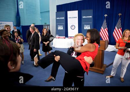 Il 27 luglio 2012 "Sonya Hebert ha catturato questo divertente momento mentre la lottatrice olimpica statunitense Elena Pirozhkova ha letteralmente conquistato la First Lady durante un saluto con gli atleti olimpici del Team USA che gareggiavano nei Giochi olimpici estivi di Londra del 2012". (Foto ufficiale della Casa Bianca di Sonya N. Hebert) questa fotografia ufficiale della Casa Bianca è resa disponibile solo per la pubblicazione da parte delle organizzazioni di notizie e/o per uso personale per la stampa da parte del soggetto(i) della fotografia. La fotografia non può essere manipolata in alcun modo e non può essere utilizzata in materiali commerciali o politici, pubblicità, e-mail, prodotti, p Foto Stock