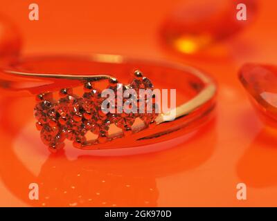 Primo piano scatto di gioielli belli e lucenti. Scatta su sfondo arancione Foto Stock