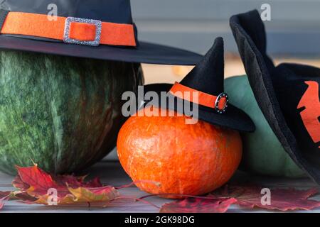 Tre zucche di Halloween in cappelli di strega sdraiati su una terrazza di legno Foto Stock