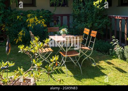 Un tavolo con sedie in giardino Foto Stock
