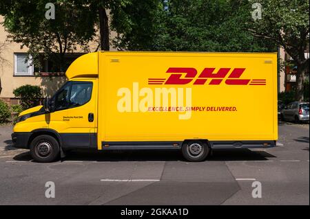 Vista laterale di un furgone DHL in piedi sul lato della strada Foto Stock