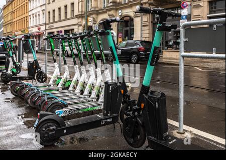 Un sacco di e-scooters di diverse aziende in piedi su un marciapiede a Berlino Foto Stock