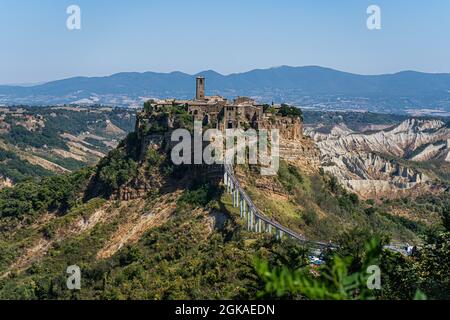 VITERBO ITALIA, REGNO UNITO. 13 Settembre 2021. I turisti camminano sul ponte per Civita di Bagnoregio, un pittoresco villaggio collinare in Italia, è una popolare destinazione di un giorno da Roma in una giornata calda. Il turismo italiano ha raggiunto un picco inestimabile nei mesi di luglio e agosto, poiché secondo la Confederazione Italiana del mestiere e delle piccole e medie imprese (CNA) con l’aumento della domanda di viaggi è stato attribuito all’attuazione del green pass del paese. Credit: amer Ghazzal/Alamy Live News Foto Stock