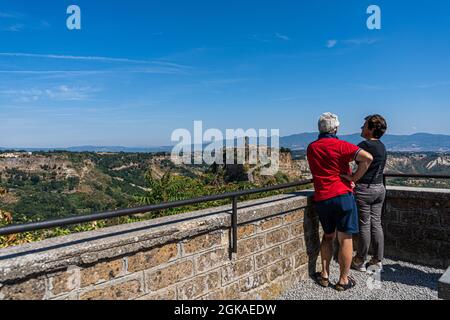 VITERBO ITALIA, REGNO UNITO. 13 Settembre 2021. I turisti camminano sul ponte per Civita di Bagnoregio, un pittoresco villaggio collinare in Italia, è una popolare destinazione di un giorno da Roma in una giornata calda. Il turismo italiano ha raggiunto un picco inestimabile nei mesi di luglio e agosto, poiché secondo la Confederazione Italiana del mestiere e delle piccole e medie imprese (CNA) con l’aumento della domanda di viaggi è stato attribuito all’attuazione del green pass del paese. Credit: amer Ghazzal/Alamy Live News Foto Stock