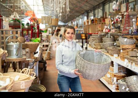 Donna scelta wickerwork in negozio Foto Stock