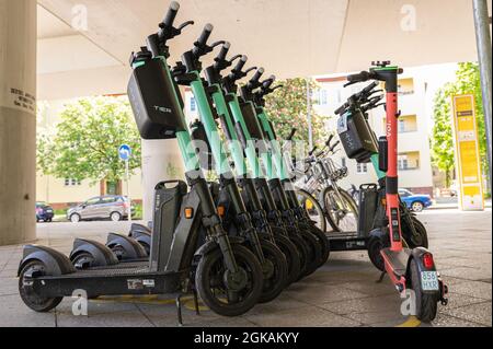 Un sacco di e-scooters di diverse aziende in piedi su un marciapiede a Berlino Foto Stock