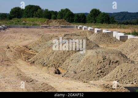 alcune pile di sabbia su un cantiere per costruire un terreno di un magazzino Foto Stock