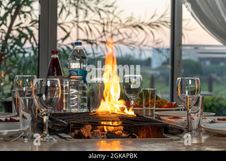 Diversi tipi di carne alla griglia sul barbecue a tavola, serviti con speciali antipasti turchi e raki turchi. Foto Stock