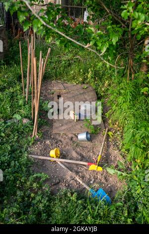 Giardino del gioco del cortile del bambino con erba verde sporca e giocattoli Foto Stock