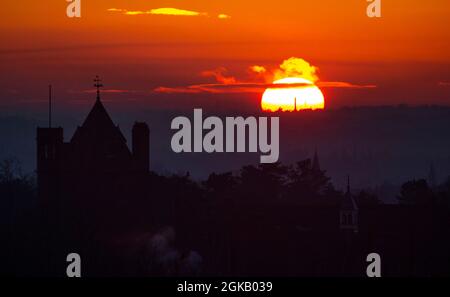 Il sole tramonta su Belfast in una fredda Domenica di Gennaio come visto dalle colline Craigantlet in Co. Down, Irlanda del Nord. Foto Stock