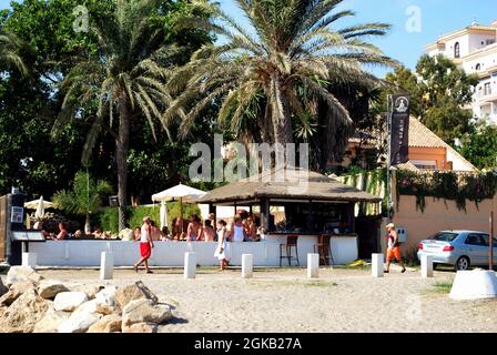 I turisti si rilassano al bar sulla spiaggia di Puerto Banus, Marbella, Spagna. Foto Stock