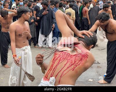 Ashura giorno sacro islamico per i musulmani sciiti; rituali azadari in lutto per il martirio di Imam Hussain. Autoflagellazione rituale con catene. Selettiva foc Foto Stock