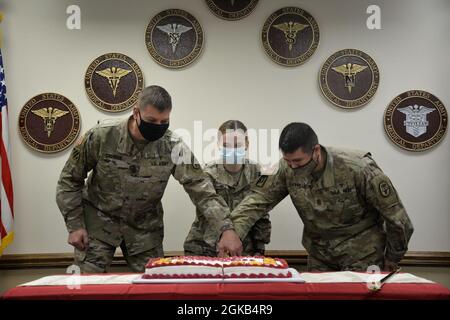 Da sinistra a destra: 1° Sgt. Jonathan Calhoun, PFC. Marley Bell e Command Sgt. Il Major John P. Castillo ha tagliato la torta cerimoniale, segnando la celebrazione del 128th Army Medical Department (AMEDD) arruolato corpo anniversario 1 marzo. Foto Stock