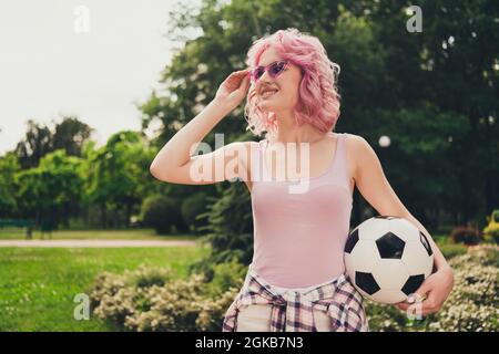 Ritratto di attraente ragazza allegra spendere vacanza tempo libero tenendo palla toccare specifiche su aria fresca all'aperto Foto Stock