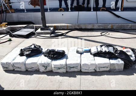 I membri dell'equipaggio Cutter Heriberto Hernandez della Guardia Costiera scaricano oltre 200 kg di cocaina, del valore di oltre 5.6 milioni di dollari, e trasferiscono tre trafficanti sospetti, uno venezuelano e due dominicani ad agenti federali della forza di attacco del Corridoio Caraibico 2 marzo 2021 alla base della Guardia Costiera San Juan. Il busto è risultato da un'interdizione in mare da parte della Cutter della Guardia Costiera Richard Dixon e agenzie partner nel Mar dei Caraibi vicino alle Isole Vergini statunitensi il 23 febbraio 2021. Foto Stock