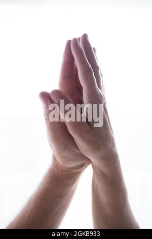 Palma di mani umane unite insieme nella posizione di preghiera di namaste su sfondo bianco dello spazio di copia. Concetto di benessere e stile di vita sano. Mano per adulti Foto Stock