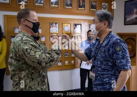 210303-N-GG858-1004 OKINAWA, Giappone (Mar. 3, 2021) Japan Maritime Self-Defense Force, Sub Area Activity Okinawa (SAAO), (a destra) partecipa a una chiamata di ufficio con il Capitano Scott Hardy, Comandante, Fleet Activities Okinawa (FAO) presso la sede della FAO a Okinawa, Giappone, 3 marzo 2021. La CFAO supporta l'intero spettro delle operazioni navali su Okinawa e i suoi principali comandi tenant sono Commander Task Force 76, Naval Mobile Construction Battaglione 5 e Patrol and Reconnaissance Force 7th Fleet. Foto Stock