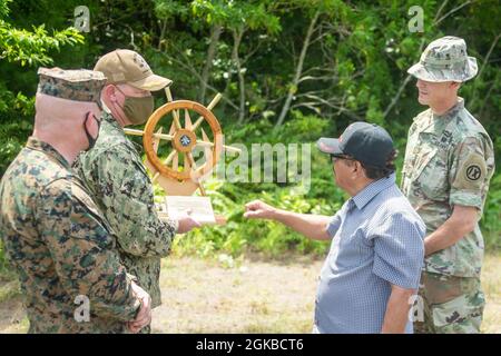 Michael Nakonieczny, 31 Marine Expeditionary Unit (MEU) comandante, Brian Schrum, comandante della USS New Orleans (LPD 18), presenta un regalo al governatore Tempy ShMall, Governatore dello Stato di Peleliu, con il Major dell'Esercito degli Stati Uniti Matthew See della Task Force Oceania sull'isola di Peleliu, Repubblica di Palau, 3 marzo 2021. Il 31 MEU opera a bordo di navi dello Squadrone anfibio 11 nel 7° settore di attività della flotta per migliorare l'interoperabilità con alleati e partner e servire come forza di reazione pronta a difendere la pace e la stabilità nel in Foto Stock