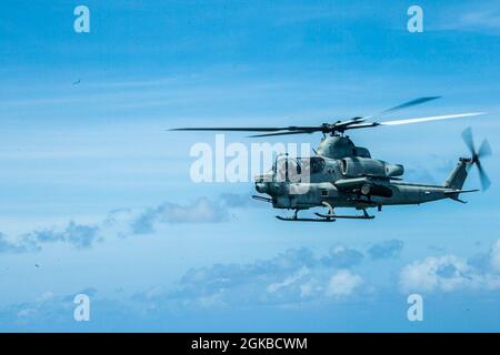 Un corpo Marino degli Stati Uniti AH-1Z Cobra con Marine Medium Tiltrotor Squadron 262 (rinforzato), 31st Marine Expeditionary Unit (MEU), vola sopra Palau dopo la partenza da USS New Orleans (LPD 18) sulla sua strada per l'isola di Peleliu, 3 marzo 2021. Il 31 MEU opera a bordo di navi dello Squadrone anfibio 11 nel 7° settore di attività della flotta per migliorare l'interoperabilità con alleati e partner e servire come forza di reazione pronta a difendere la pace e la stabilità nella regione Indo-Pacifico. Foto Stock